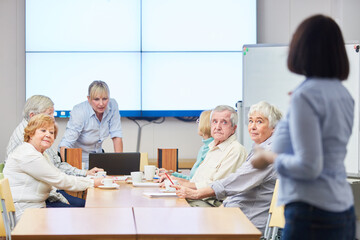Dozentin mit einer Gruppe Senioren in einem VHS Kurs für Weiterbildung im Alter