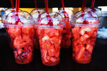 Making a watermelon cocktail. Slices of watermelon in plastic glasses.