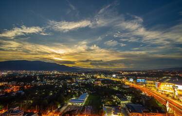 Fototapeta premium CHIANG MAI, THAILAND - JUNE 28, 2020 : Aerial night view of Chiang Mai Cityscape from a high angle with Doi Suthep and super highway at dusk in Chiang Mai, Thailand.