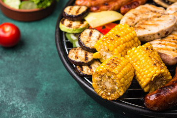Grilled sausages, meat, and vegetables.