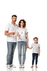 handsome man pointing with finger at card with stay at home lettering near attractive wife and kid on white