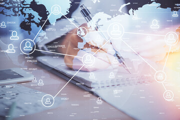 Social network theme hologram over hands taking notes background. Concept of global international people connect. Double exposure