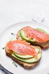 Open sandwich with avocado, smoked salmon and rye bread.