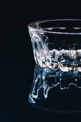 Small low glass bowl on black background. Clean empty glass.