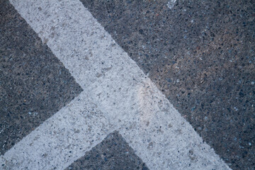 Close up of street line on grainy asphalt. Texture of ashpalt with road markings.