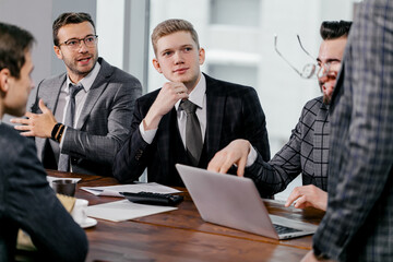 leadership and business concept. business team in modern office sit having active discussion of business ideas together, wearing tuxedo, formalwear