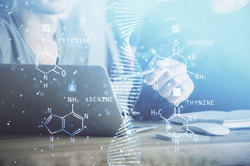 DNA hologram with businessman working on computer on background. Concept of bioengineering. Double exposure.