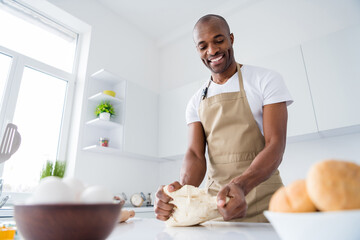 Portrait of his he nice attractive cheerful focused guy confectioner preparing fresh tasty yummy bread pizza pie pide doughing flour enjoying hobby in modern light white interior house kitchen