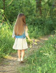 little girl with long hair in the woods