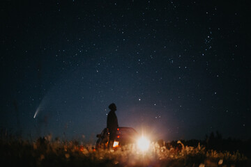 Young man on the background of the starry sky and comet NEOWISE. Comet C / 2020 F3 NEOWISE Observation