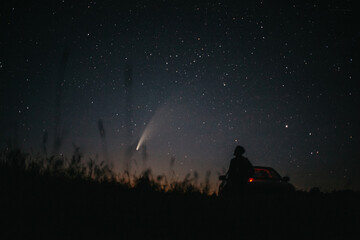 Young man on the background of the starry sky and comet NEOWISE. Comet C / 2020 F3 NEOWISE Observation - obrazy, fototapety, plakaty