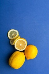 Top view of heap of fresh ripe lemons on the blue background.Empty space