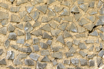 Rustic antique wood background of an old farm house wall made with clay and wooden logs.
