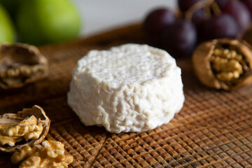 Premium organic goat cheese  on a rustic wooden cheese maker.