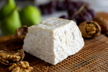 Premium organic goat cheese  on a rustic wooden cheese maker.