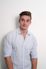 Portrait of young handsome businessman thinking and looking up