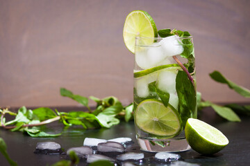Summer coctail mojito with ice, mint, lime on a grey background. Copy space.