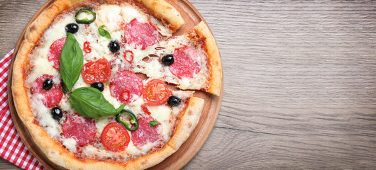 Top view of hot delicious pizza on wooden table, space for text. Banner design