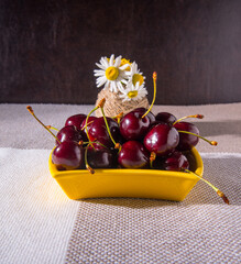 Saucers with cherries, a bouquet of flowers on the table