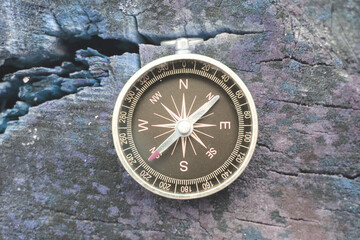 round compass on blue wooden background as symbol of tourism with compass, travel with compass and outdoor activities with compass