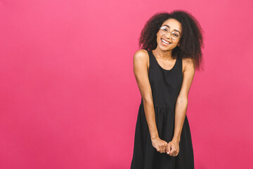 Portrait of beautiful positive african american black woman standing isolated over pink background.