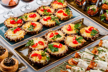 Delicious appetizers in tart with cheese and meat in plate on banquet table. Catering food, canape and snacks