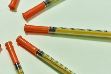 Close up of insulin syringes for diabetes lying in a circle isolated over light background. Injection medicine concept