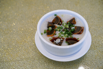 Congee with century egg. Chinese rice porridge served with century egg. A famous Chinese traditional breakfast. (Isolated)
