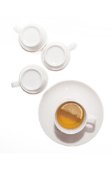 A mug of lemon tea and a few inverted cups