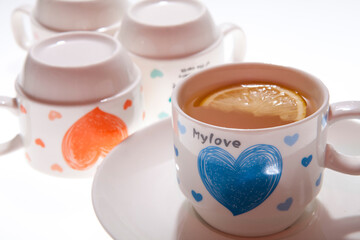 A mug of lemon tea and a few inverted cups