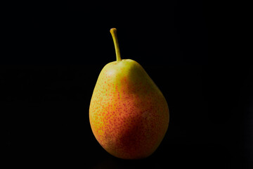 Closeup of yellow-red pear isolated on black background