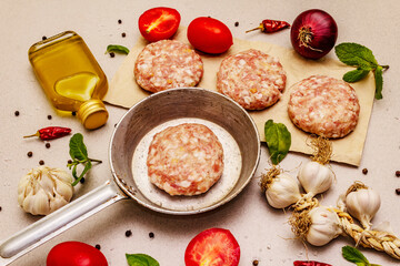 Raw cutlets, fresh vegetables, spices, olive oil. Vintage pan, picnic or barbecue cooking concept