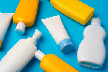 Bottles of sunscreen cream on blue background