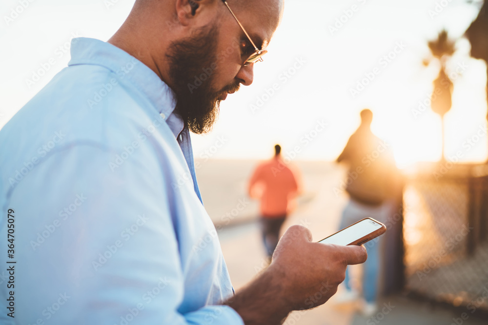 Poster selective focus, hipster guy checking mail on smartphone sending message via good internet connectio