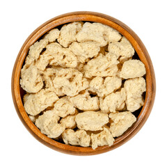 Soya chunks in wooden bowl. Textured soy protein, also known as soy meat. Defatted soy flour product, used as meat analogue or meat extender. Closeup from above, over white, isolated macro food photo.