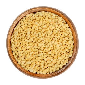 Soya granules in wooden bowl. Textured soy protein, also called soy meat. Defatted soy flour product, used as meat analogue or meat extender. Closeup from above, over white, isolated macro food photo.