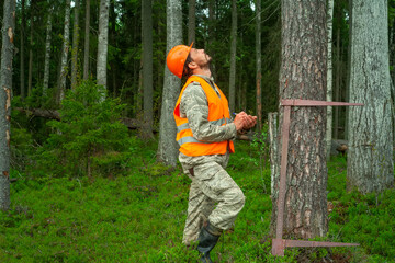 Naklejka na ściany i meble Forest worker makes a taxation of forest stands. Forester in work clothes. Real people work.
