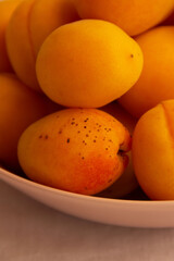 apricots in a plate on a light background in the morning light