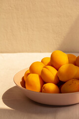 apricots in a plate on a light background  in the morning light