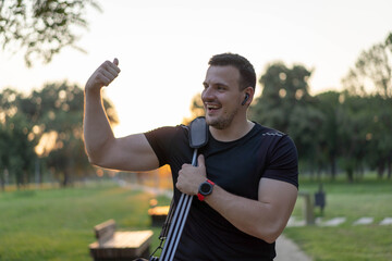  Attractive Man walking in a park after workout, wearing sport bag.
