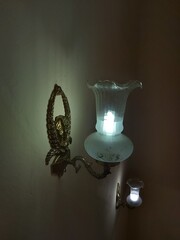 beautiful design of lamps in the wall. Gothic lamps, Gothic lamp in the wall on stairs. White light and Yellow wall. Beautiful dark shadow. Archidona, Malaga, Spain. 06/07/2020.