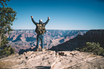 Back view of male travel excited with getting on top of mountain with backpack during exploring...