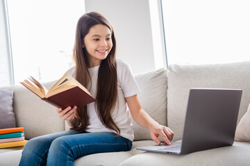 Photo of little pretty pupil school lady turn on skype laptop notebook online lesson hold open book...