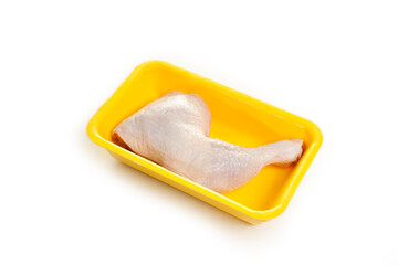 fresh raw chicken leg in yellow foam isolated in white background.