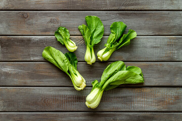 Bok choy on wooden background top view