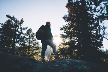 Young hipster guy traveler recreating walking in forest with backpack discover wild nature landscape and environment, caucasian male tourist enjoy active leisure wanderlust destination and location