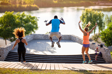 Hombre negro y dos mujeres blancas haciendo deporte en el parque