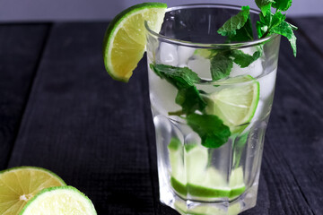 Mojito cocktail or soda drink with lime and mint isolated on wood background
