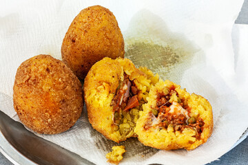hot palatable arancini on the paper napkin. Sicily street food. Selective focus