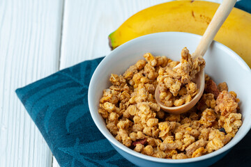 Bowl with granola on wooden table close up